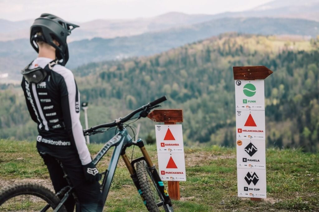 Bike park Wisła: rowerzysta przy tablicach tras Bike Parku Soszów z widokiem na Beskidy